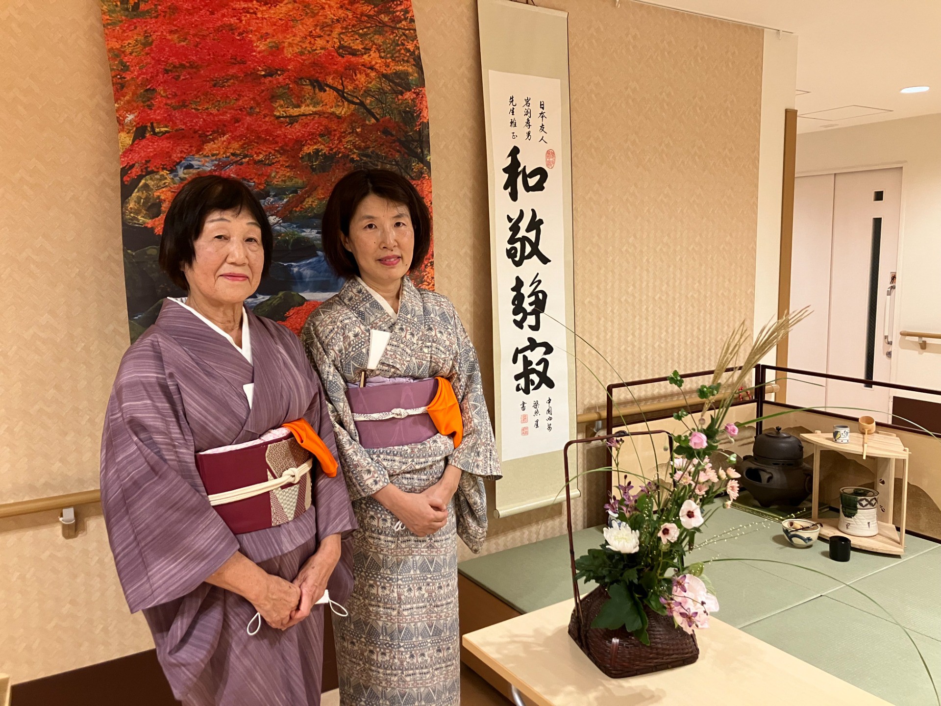 イルアカーサの秋のお茶会での表千家教授 金丸様と職員。背景にはお茶会の様子   iruacasa-autumn-tea-gathering-kanamaru-staff